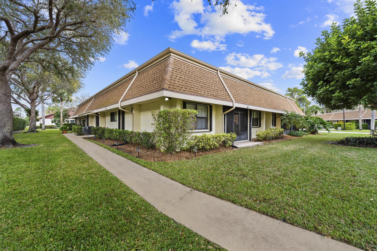 A low-rise apartment building with a mansard roof and a concrete walkway on the lawn — 109 Half Moon Circle # C, Jupiter FL 33458, JUPITER, FL