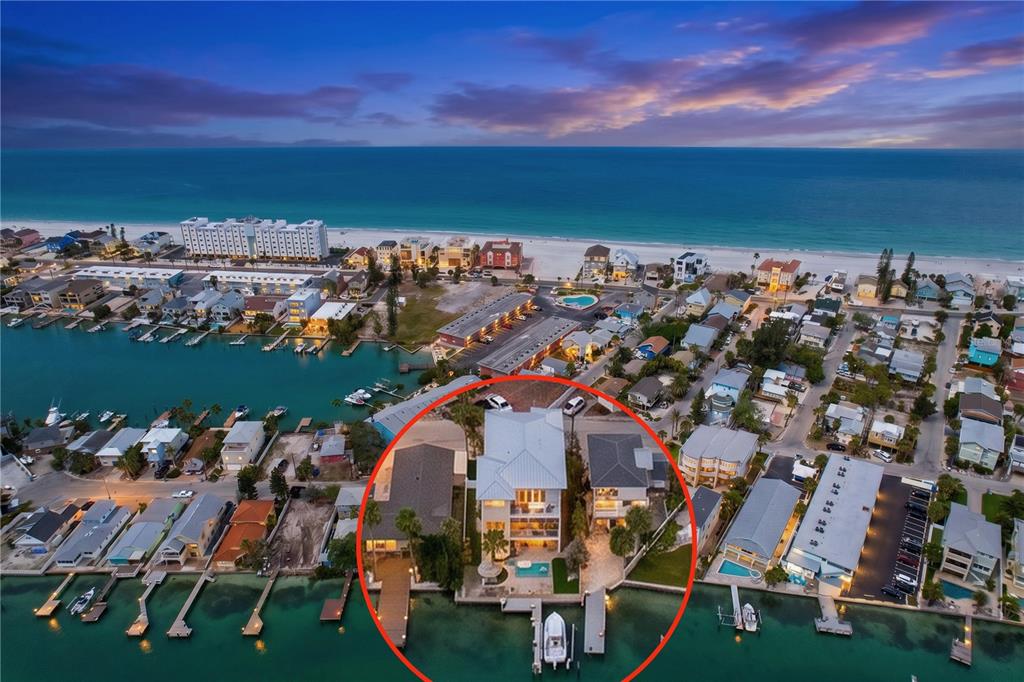 An aerial view shows a waterfront house with a pool and dock inside a circle — 306 BAY PLZ, TREASURE ISLAND, FL