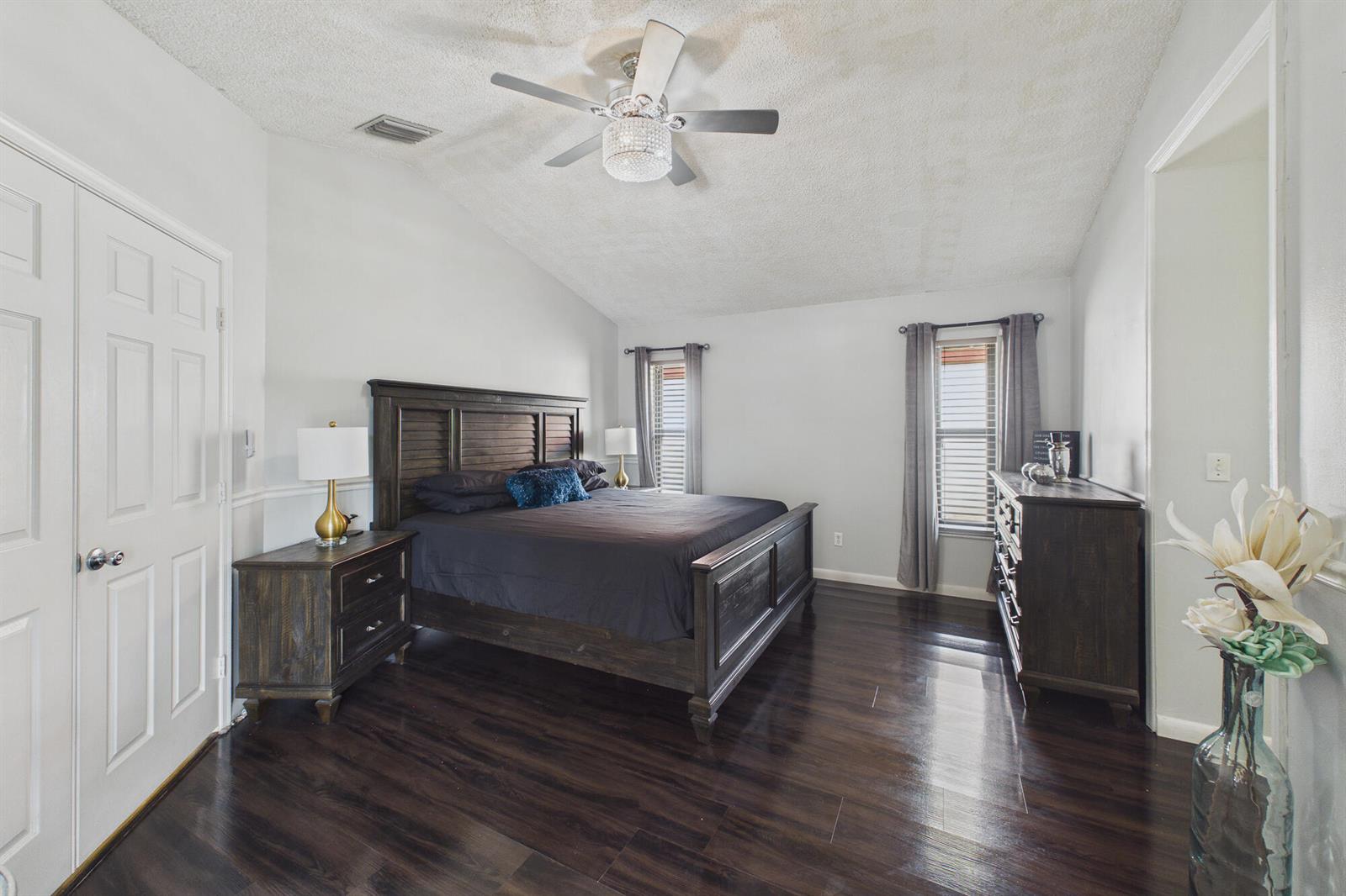 A bedroom features dark wood furniture, dark hardwood floors, and a ceiling fan with lights — 169 Executive Circle, Boynton Beach FL 33436, BOYNTON BEACH, FL