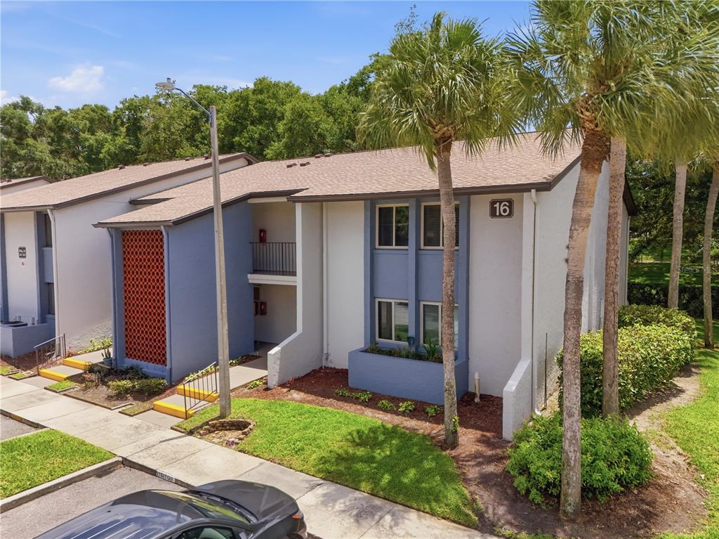 An exterior view of a two-story apartment building with blue accents and a numbered sign — 16 ESCONDIDO CIRCLE UNIT 223, ALTAMONTE SPRINGS, FL