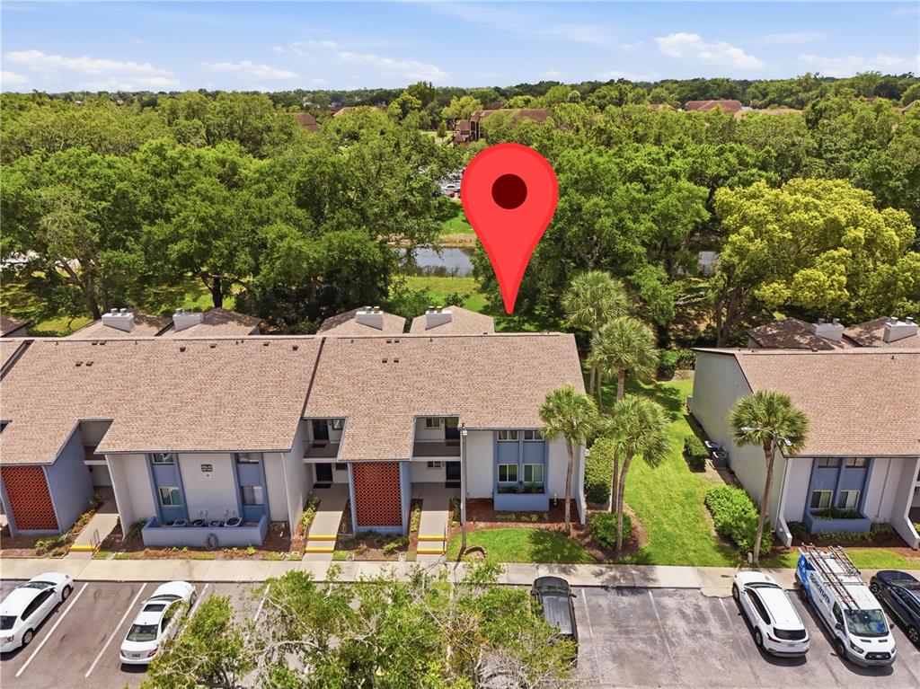 An aerial view shows a multi-unit residential building with brown shingled roofs and parking — 16 ESCONDIDO CIRCLE UNIT 223, ALTAMONTE SPRINGS, FL