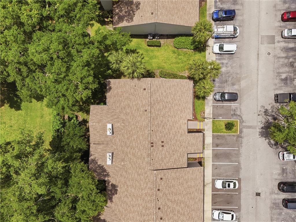 An aerial view shows a residential building with a shingled roof next to a parking lot — 16 ESCONDIDO CIRCLE UNIT 223, ALTAMONTE SPRINGS, FL