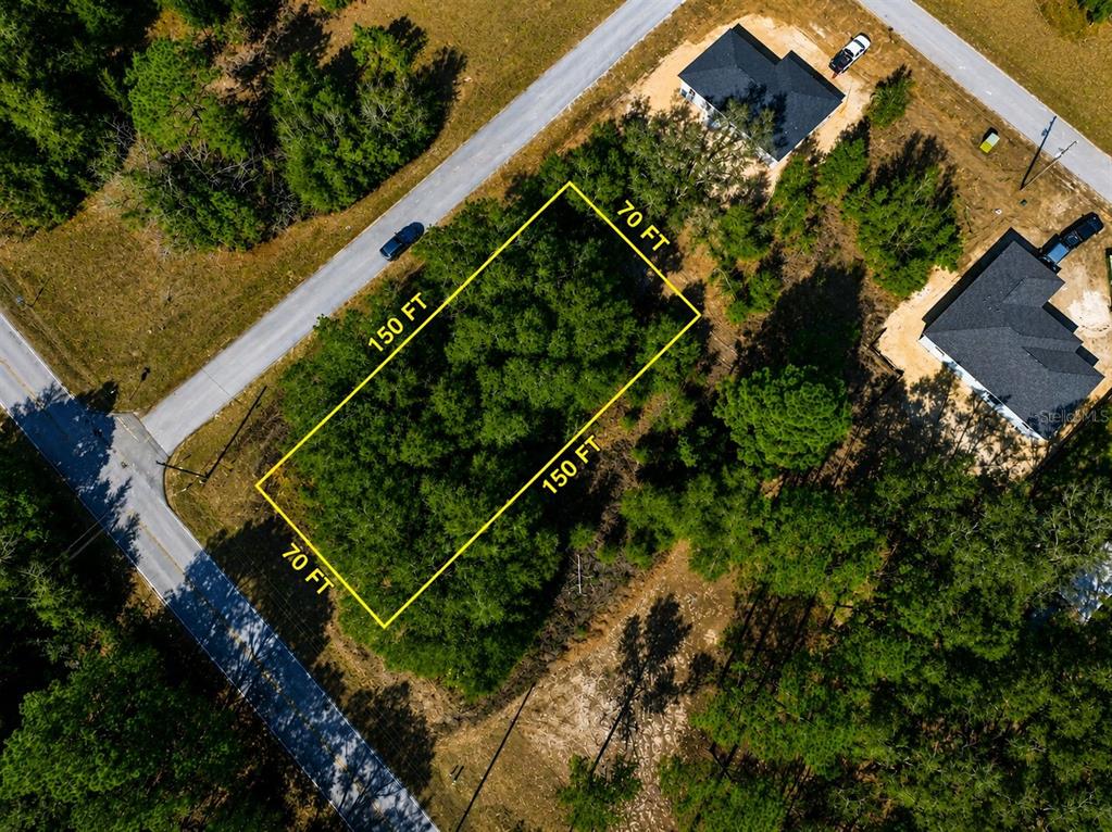 An aerial view shows a rectangular, wooded vacant lot outlined in yellow — TBD SW MARINE BLVD, DUNNELLON, FL