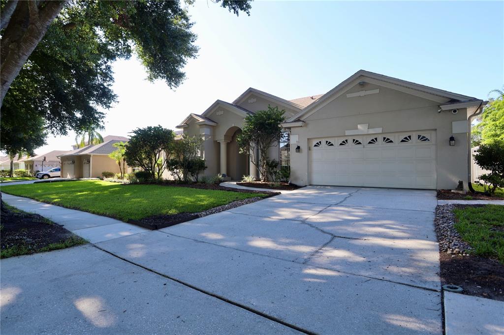 A beige single-story house with a two-car garage and a concrete driveway — 7902 GLEN CREST WAY, ORLANDO, FL