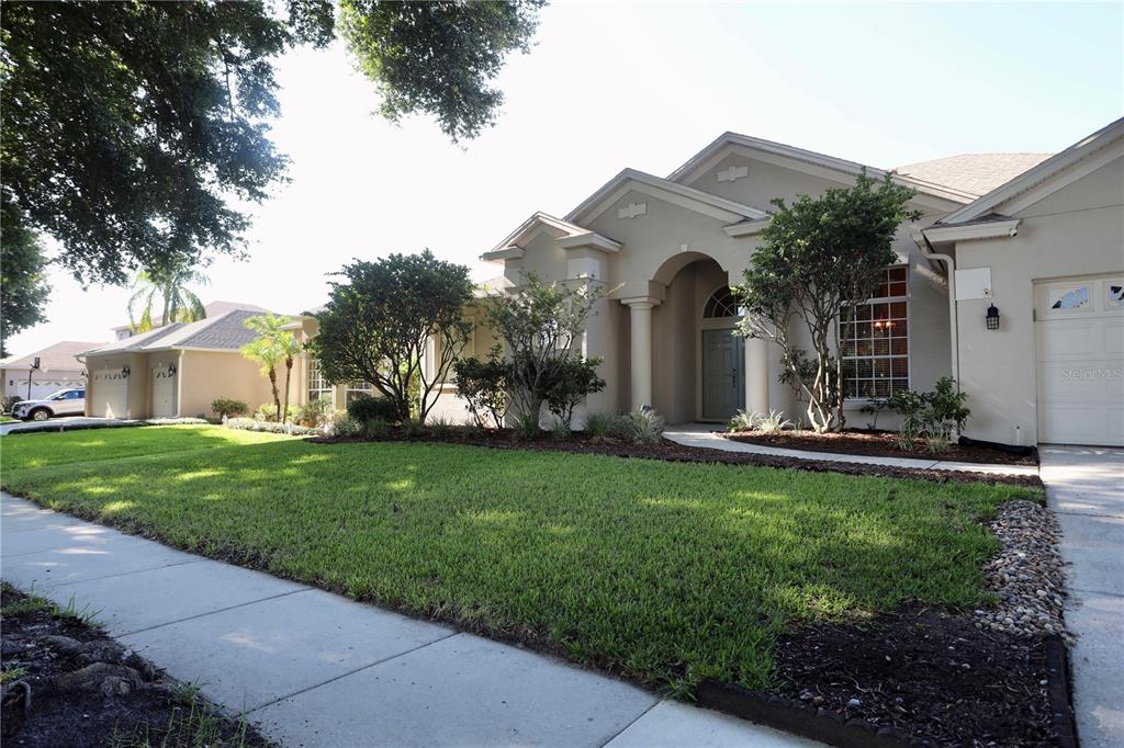 A single-story suburban house with a beige stucco exterior, a front lawn, and a garage — 7902 GLEN CREST WAY, ORLANDO, FL