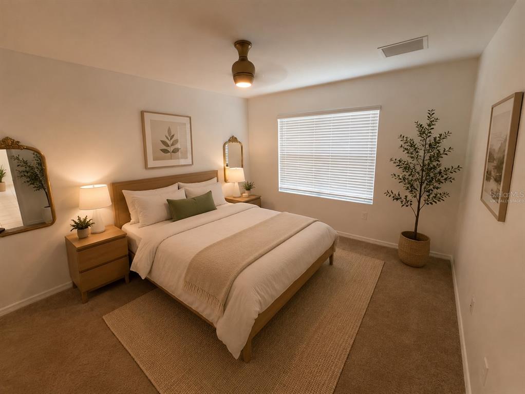 A bedroom features a queen bed, two nightstands with lamps, a mirror, and a potted plant — 27956 ARROWHEAD CIRCLE, PUNTA GORDA, FL