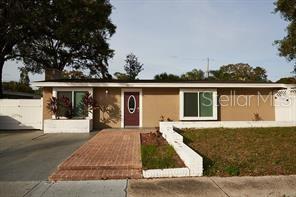 A white brick fireplace with a mantel and a round mirror sits in a living room — 4433 W OKLAHOMA AVENUE, TAMPA, FL