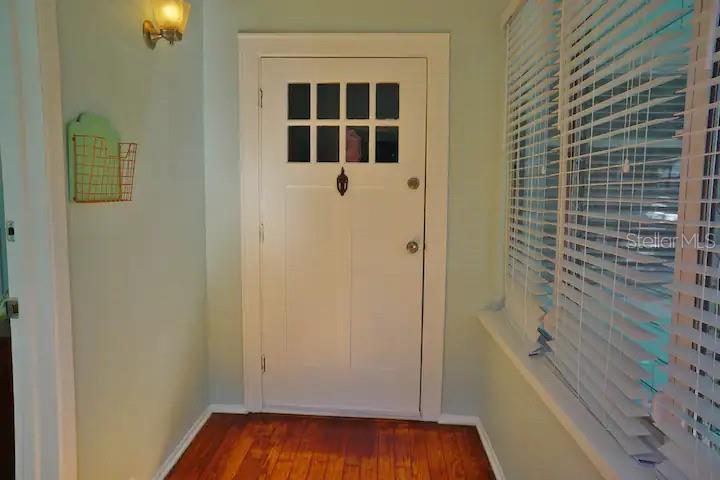 An entryway features a white door with glass panes, hardwood floors, and a wall-mounted organizer — 601 N OSCEOLA AVENUE, CLEARWATER, FL