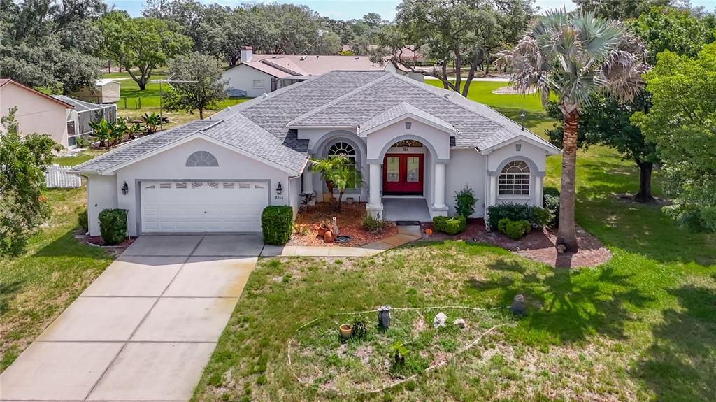 An aerial view of a single-story house with a grey roof and red front door — 8206 PINEHURST DRIVE, SPRING HILL, FL