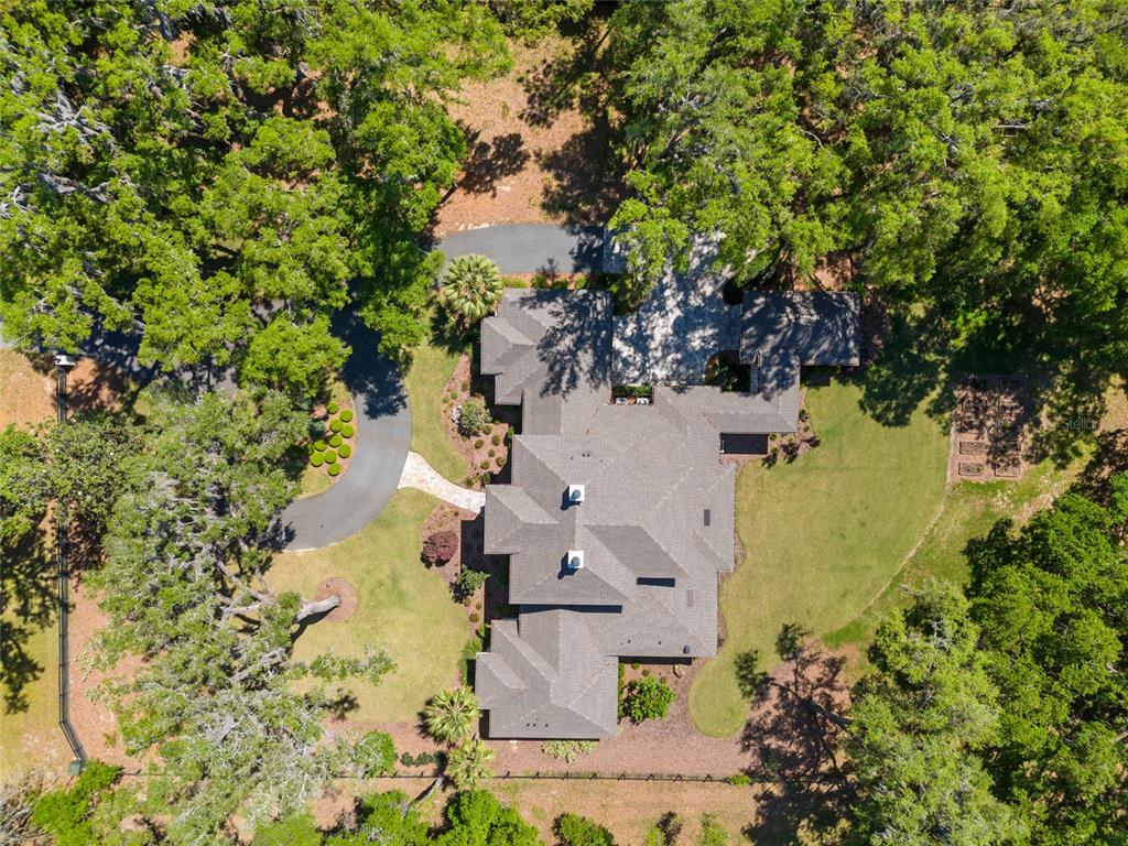An aerial view shows a house with a gray roof surrounded by trees and lawns — 14819 NW 21ST AVENUE, NEWBERRY, FL