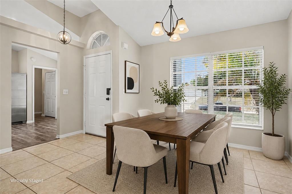 A dining room with a wooden table, six chairs, tile flooring, and a large window — 5626 S LOMA VISTA COURT, DAVENPORT, FL