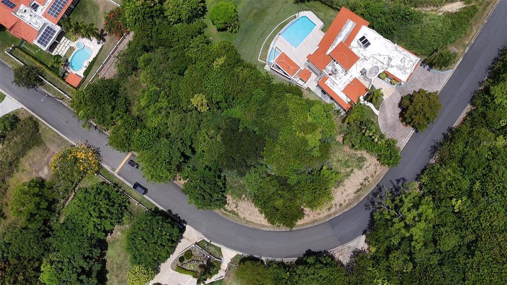 An aerial view shows a house with a red roof, pool, and surrounding dense trees — 22 HARBOUR LIGHTS UNIT 22, HUMACAO, PR