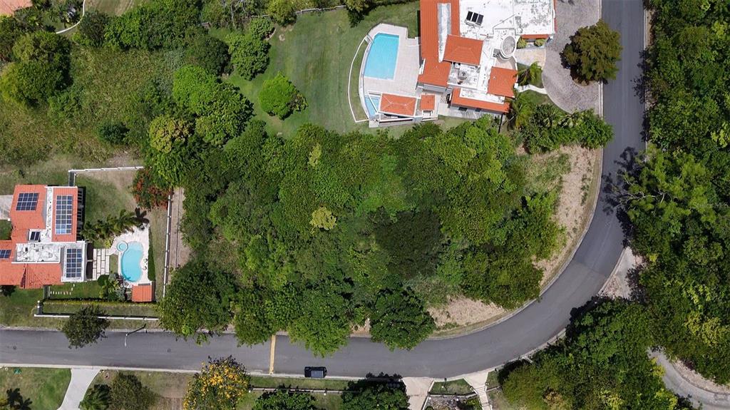 An aerial view shows a wooded lot situated between two houses with swimming pools — 22 HARBOUR LIGHTS UNIT 22, HUMACAO, PR