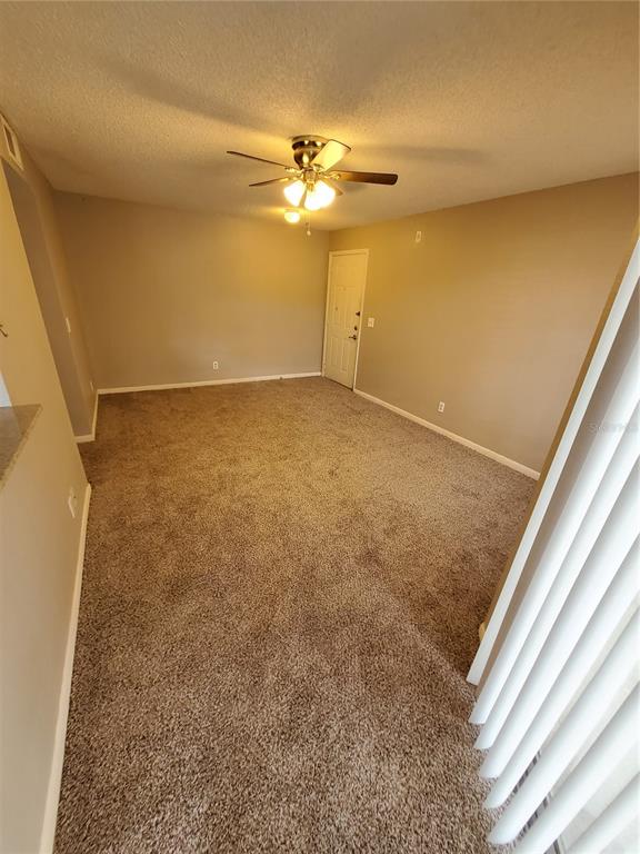An empty room with beige carpet, tan walls, and a ceiling fan — 11526 WESTWOOD BOULEVARD UNIT 725, ORLANDO, FL