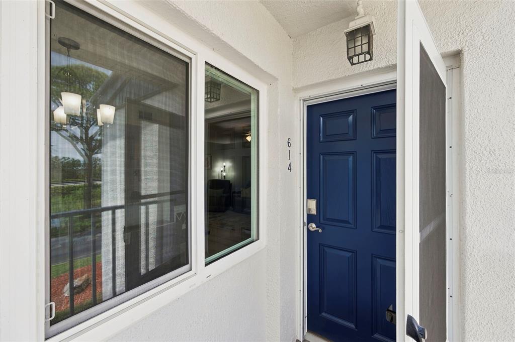 A blue front door with the number 614 next to a window on a white wall — 14800 WALSINGHAM ROAD UNIT 614, LARGO, FL