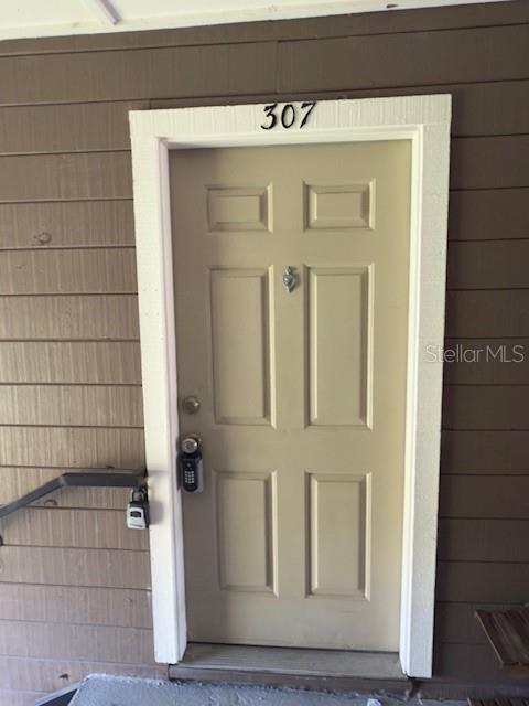 A tan exterior door labeled 307 features a keypad lock and a small metal knocker — 208 AFTON SQUARE UNIT 10-307, ALTAMONTE SPRINGS, FL