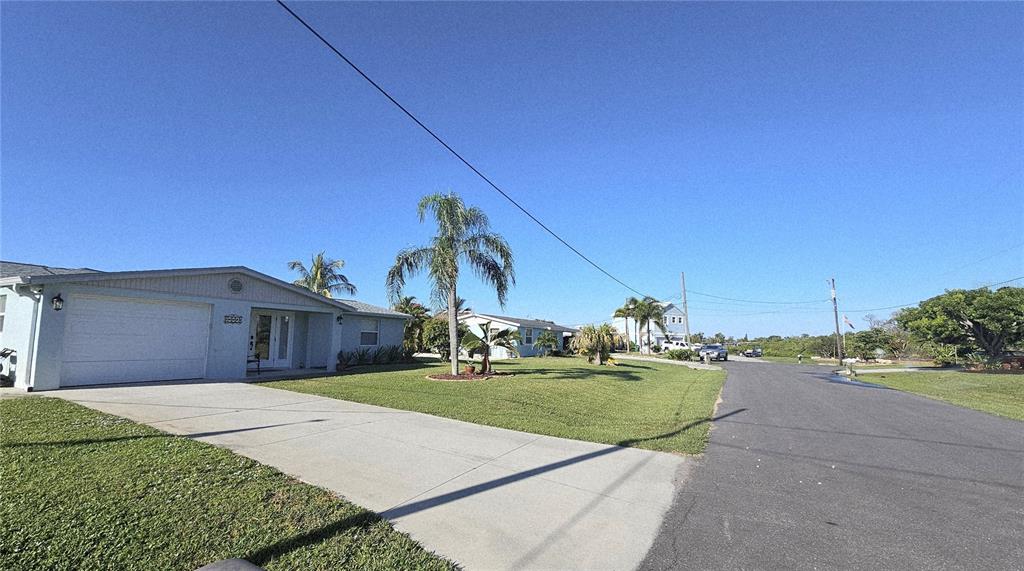A light blue single-story house with a white garage and a large front lawn — 1153 CLARK STREET, ENGLEWOOD, FL