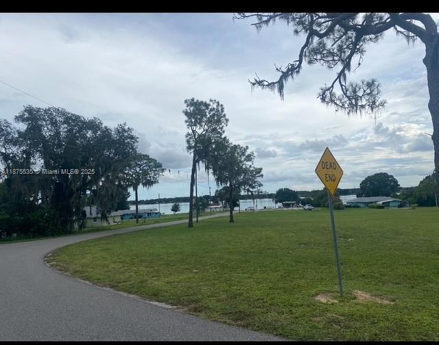 A paved road leads toward a grassy field with a dead end sign near a lake — 6005 Lake Front Dr, Sebring FL 33876, SEBRING, FL