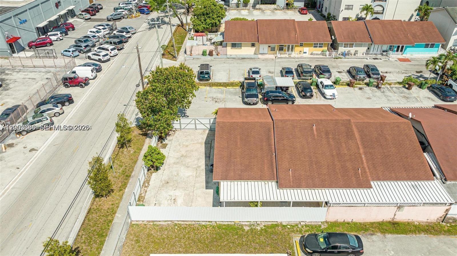 An aerial view shows a residential building with a fenced concrete yard and parking lot — 330 W 74th Pl # 330, Hialeah FL 33014, HIALEAH, FL