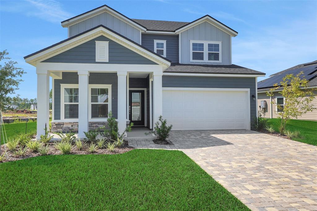 A two-story house with blue siding, a white porch, and a paved driveway — 864 BROOK FOREST DRIVE, ST AUGUSTINE, FL