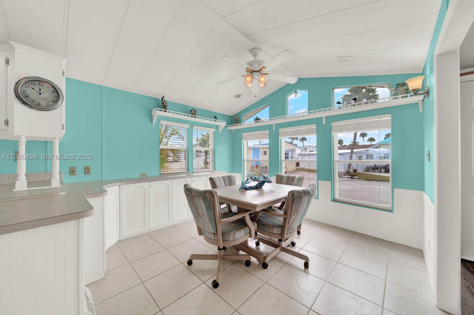 A bright dining room features turquoise walls, white cabinetry, tile flooring, and a vaulted ceiling — 10725 S Ocean Drive Unit #534, Jensen Beach FL 34957, JENSEN BEACH, FL