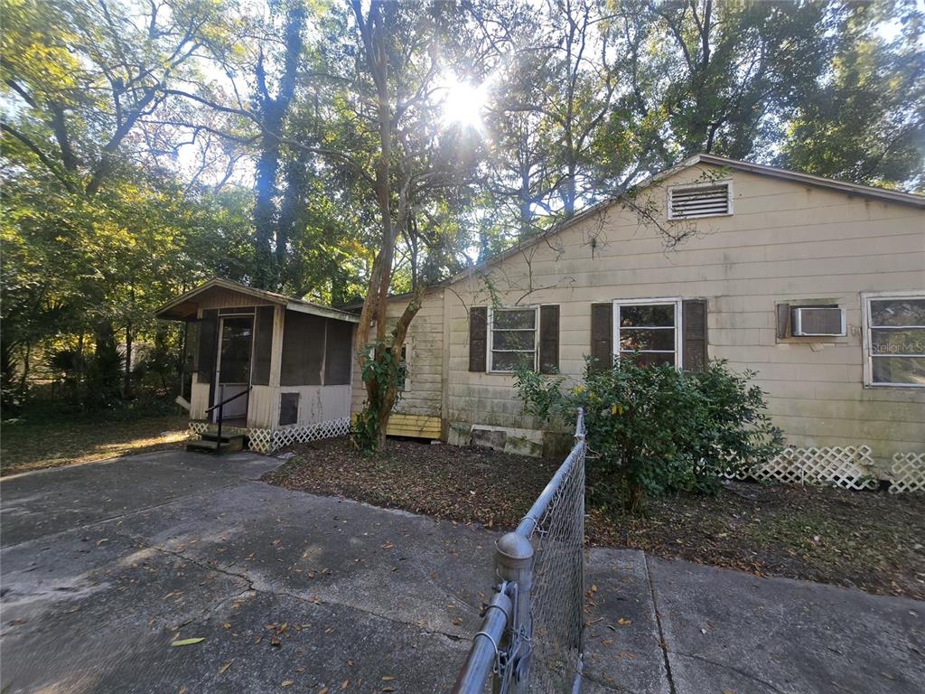 A single-story house with light-colored siding, a screened-in porch, and a chain-link fence — 1331 DENA STREET, JACKSONVILLE, FL