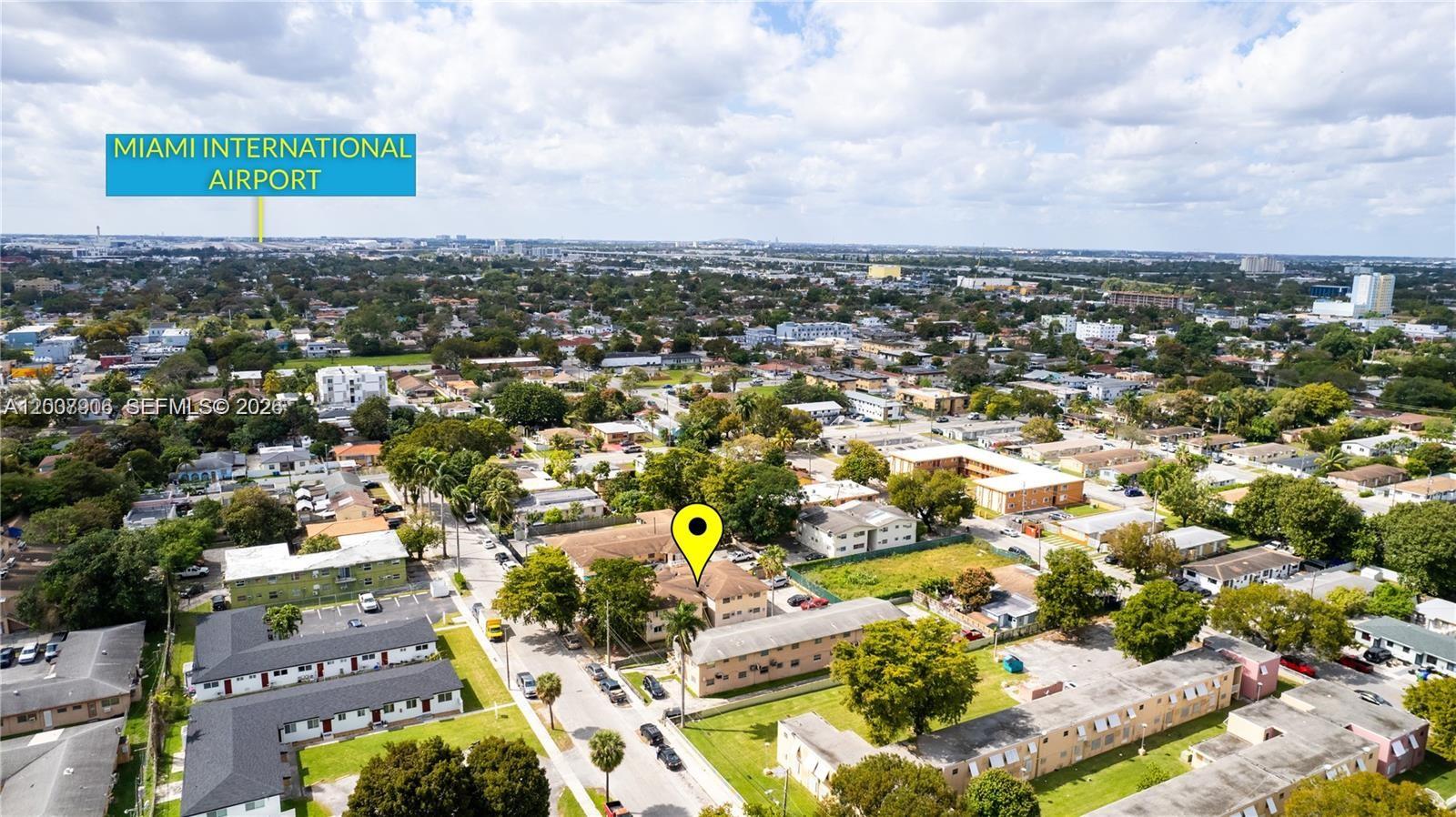 An aerial view shows a multi-family residential complex in a suburban neighborhood near an airport — 1945 NW 29th St # A8, Miami FL 33142, MIAMI, FL