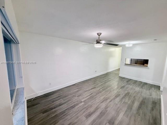 An empty room features gray wood-look flooring, white walls, and a ceiling fan — 1945 NW 29th St # A8, Miami FL 33142, MIAMI, FL