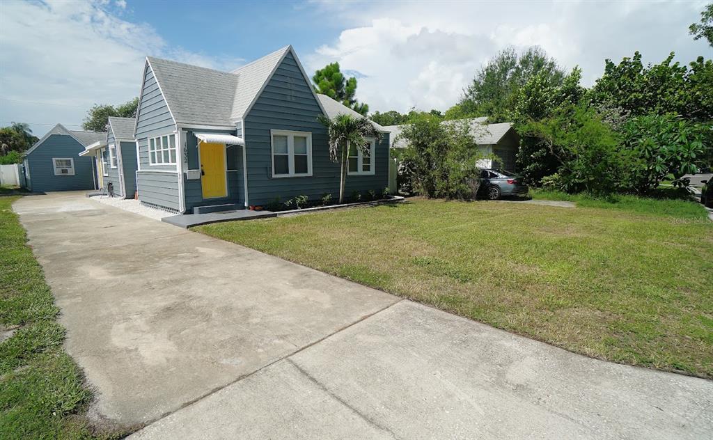 A blue house with a yellow front door and a long concrete driveway — 1632 27TH AVENUE N, ST PETERSBURG, FL
