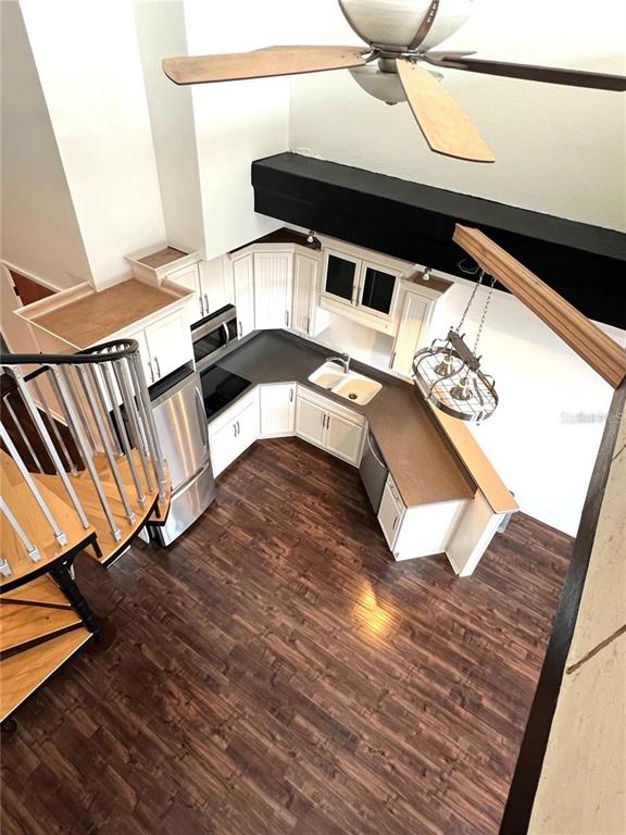 A high-angle view shows a kitchen with white cabinets, dark countertops, and a spiral staircase — 101 PALM HARBOR PARKWAY UNIT A404, PALM COAST, FL