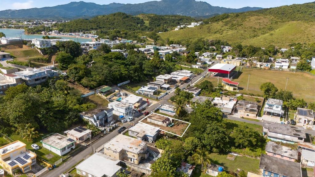 An aerial view shows a residential neighborhood with a highlighted plot of land — COMM. HUCARES 119, NAGUABO, PR