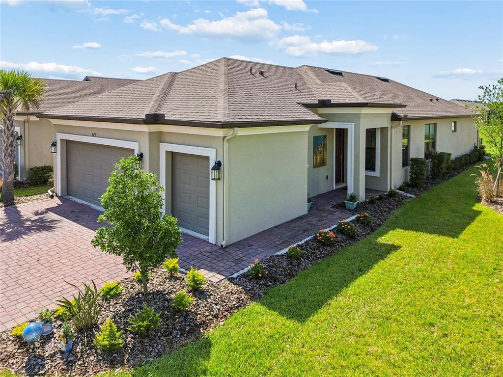 An exterior view of a single-story house with a two-car garage and paved driveway — 779 VIA COMO ST, POINCIANA, FL