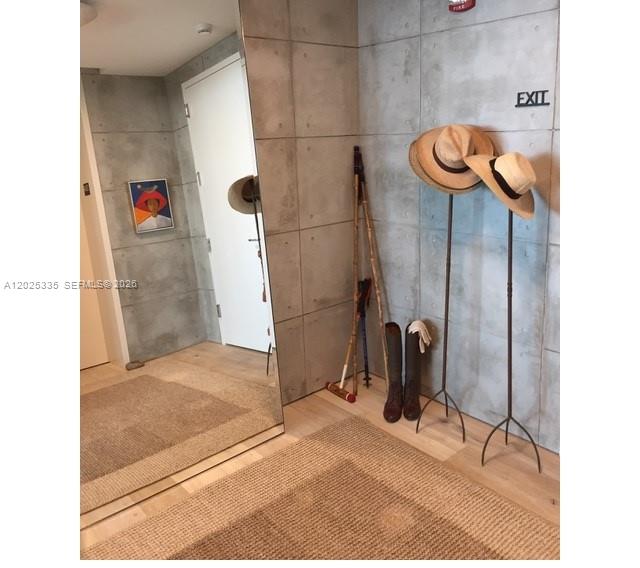 An entryway features a large mirror, concrete-style wall panels, a rug, and two hat stands — 350 OCEAN DR # 304N, Key Biscayne FL 33149, KEY BISCAYNE, FL