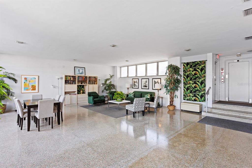 A spacious lobby features a dining area, a seating area, and polished terrazzo flooring — 750 BURLINGTON AVENUE N UNIT 3C, ST PETERSBURG, FL