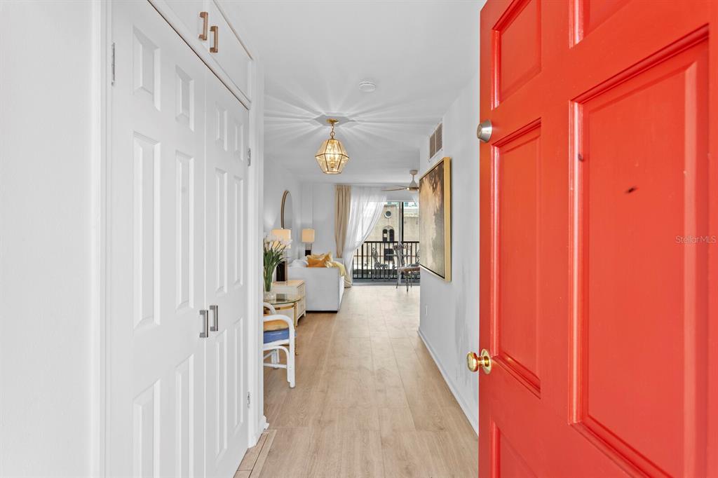 An entryway leads into a bright living area with light wood flooring and a balcony — 750 BURLINGTON AVENUE N UNIT 3C, ST PETERSBURG, FL