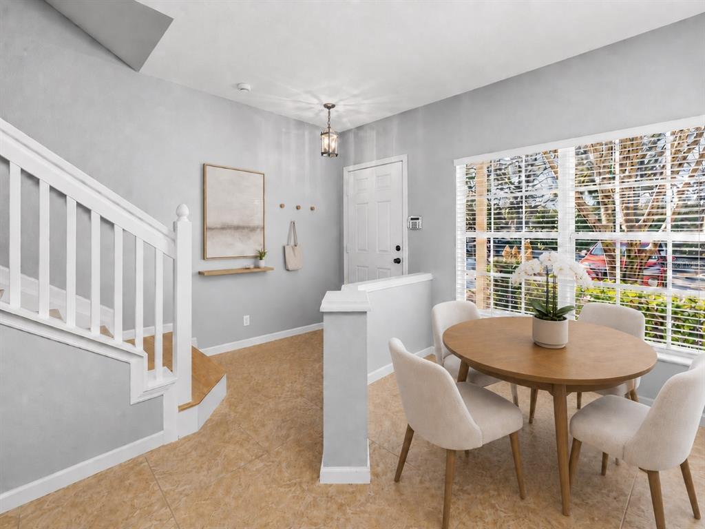 An entryway with a staircase, a dining table with chairs, and a front door — 1450 STOCKTON DRIVE, SANFORD, FL