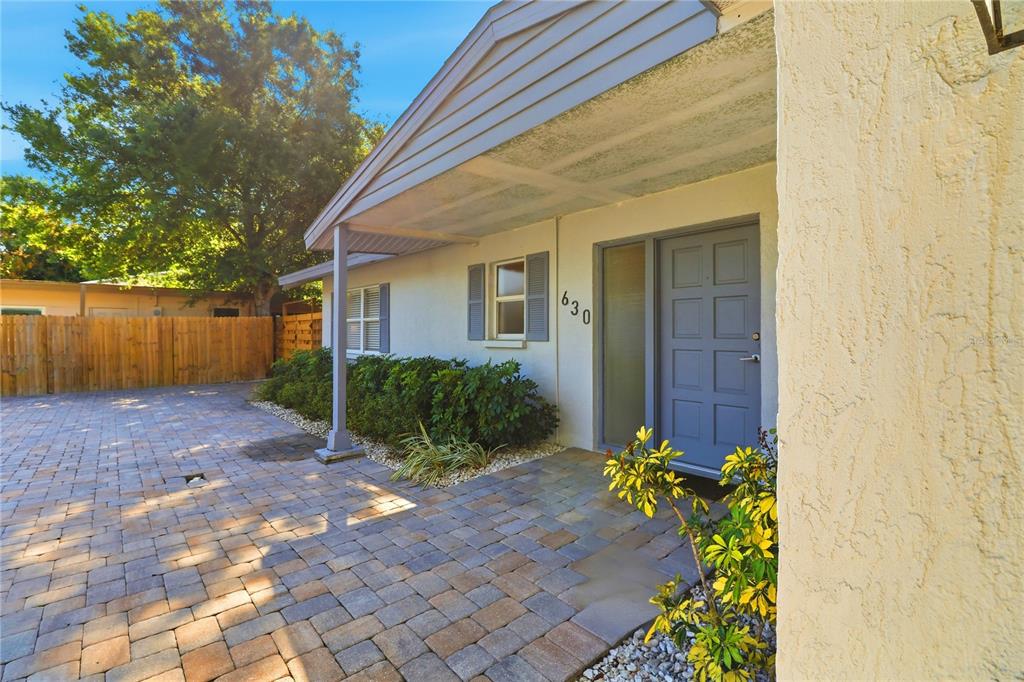 The exterior of a house features a paved driveway, a covered entryway, and a blue door — 630 CORWOOD DRIVE, SARASOTA, FL
