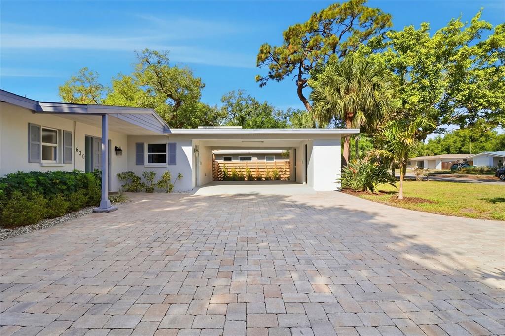 A house exterior features a paved driveway, a covered carport, and a light-colored facade — 630 CORWOOD DRIVE, SARASOTA, FL