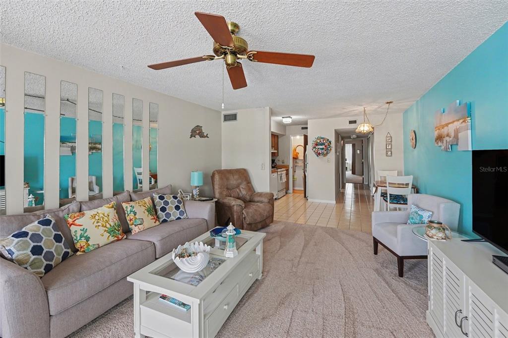 A living room features a gray sofa, a brown recliner, and a white coffee table — 6400 46TH AVENUE N UNIT 214, KENNETH CITY, FL