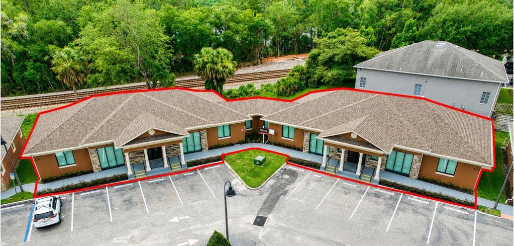 An aerial view shows a single-story commercial building with a parking lot and surrounding trees — 741 CIARA CREEK COVE, LONGWOOD, FL