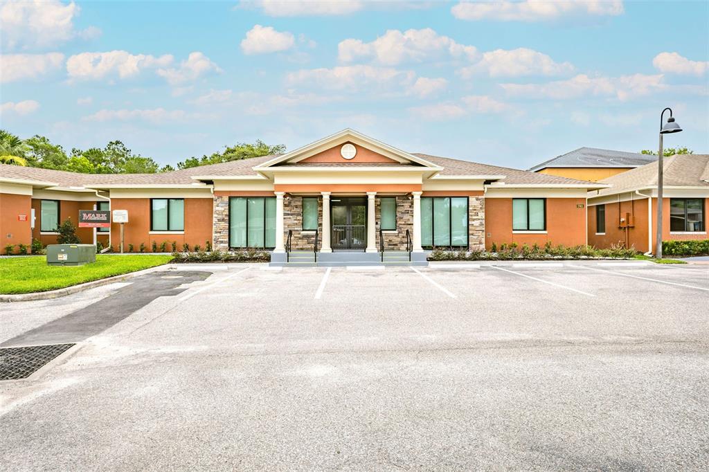 A single-story commercial building with a tan stucco facade and a stone-accented entrance — 741 CIARA CREEK COVE, LONGWOOD, FL