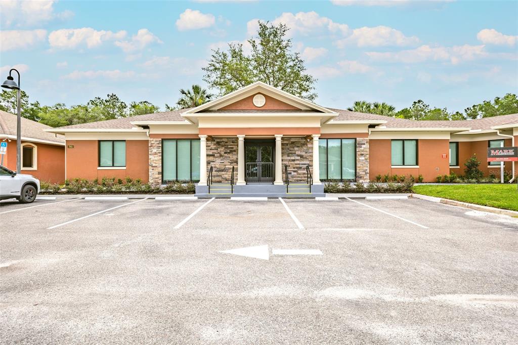 A single-story commercial building with a stone-accented entrance and a paved parking lot in front — 741 CIARA CREEK COVE, LONGWOOD, FL