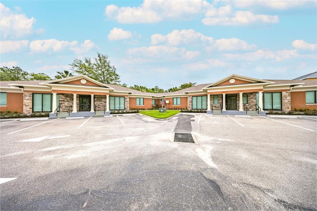 A low-rise commercial building with a paved parking lot and two symmetrical entrance porticos — 741 CIARA CREEK COVE, LONGWOOD, FL