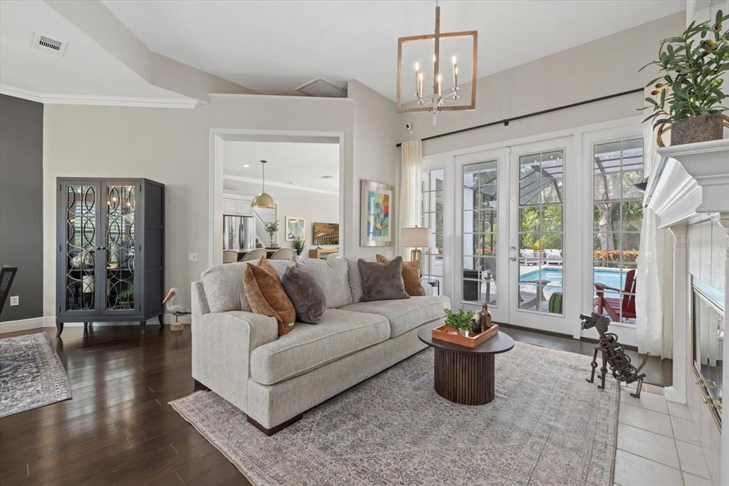 A living room features a light gray sofa, a round coffee table, and glass doors — 7574 TORI WAY, BRADENTON, FL
