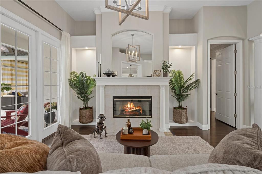 A living room features a fireplace with a mirror above and built-in shelving on both sides — 7574 TORI WAY, BRADENTON, FL