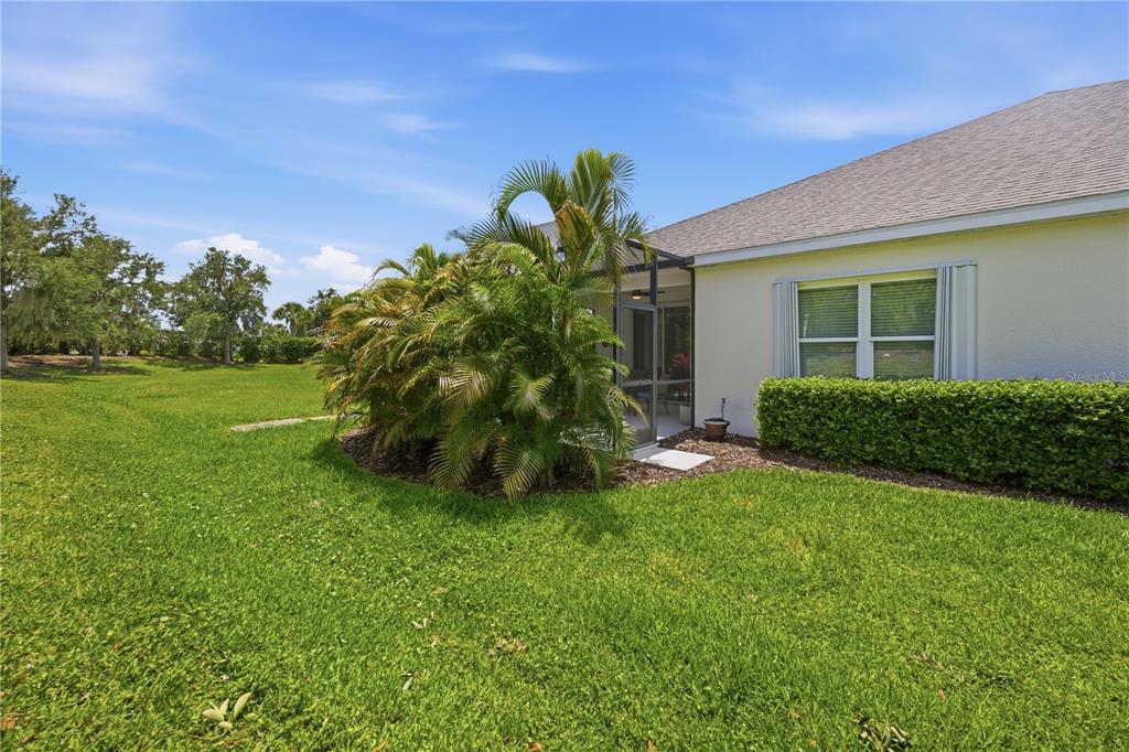 A backyard view shows a house with a screened-in patio, palm trees, and green lawn — 4504 DEEP CREEK TERRACE, PARRISH, FL