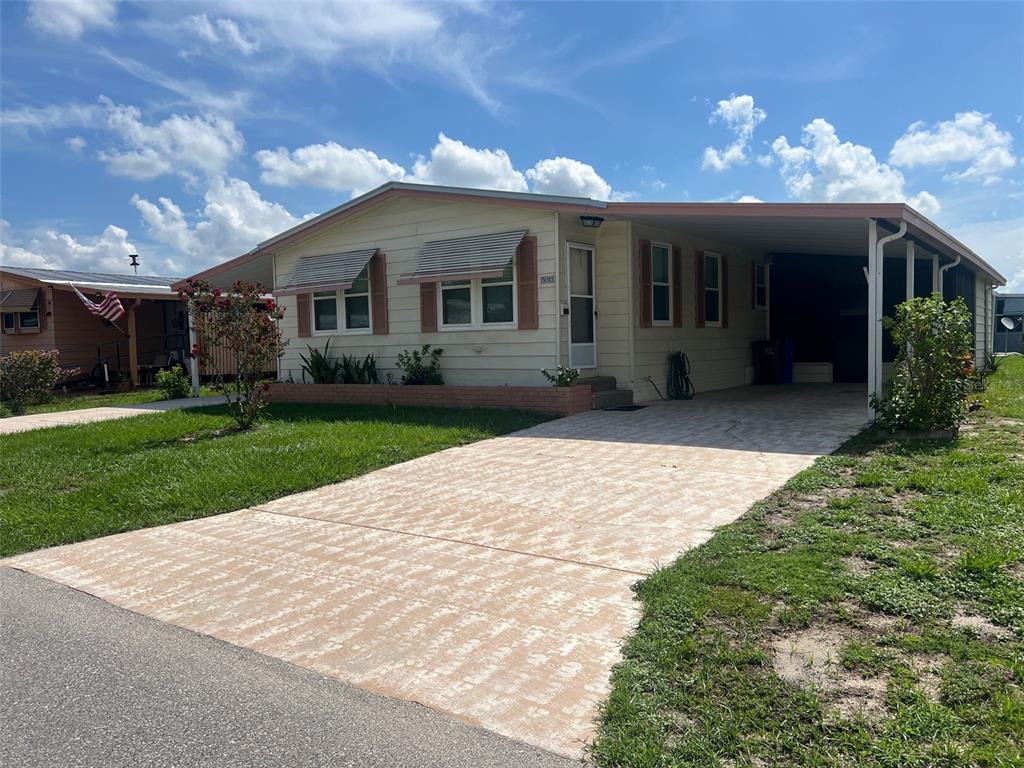 A sign for FoxWood Lake Estates stands in a landscaped bed with deer statues — 5013 FOXWOOD BOULEVARD, LAKELAND, FL
