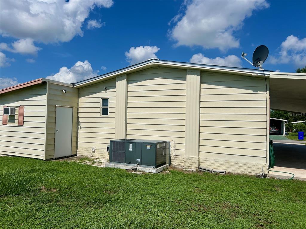 A view of a grassy park with palm trees, a pond, and houses in the background — 5013 FOXWOOD BOULEVARD, LAKELAND, FL