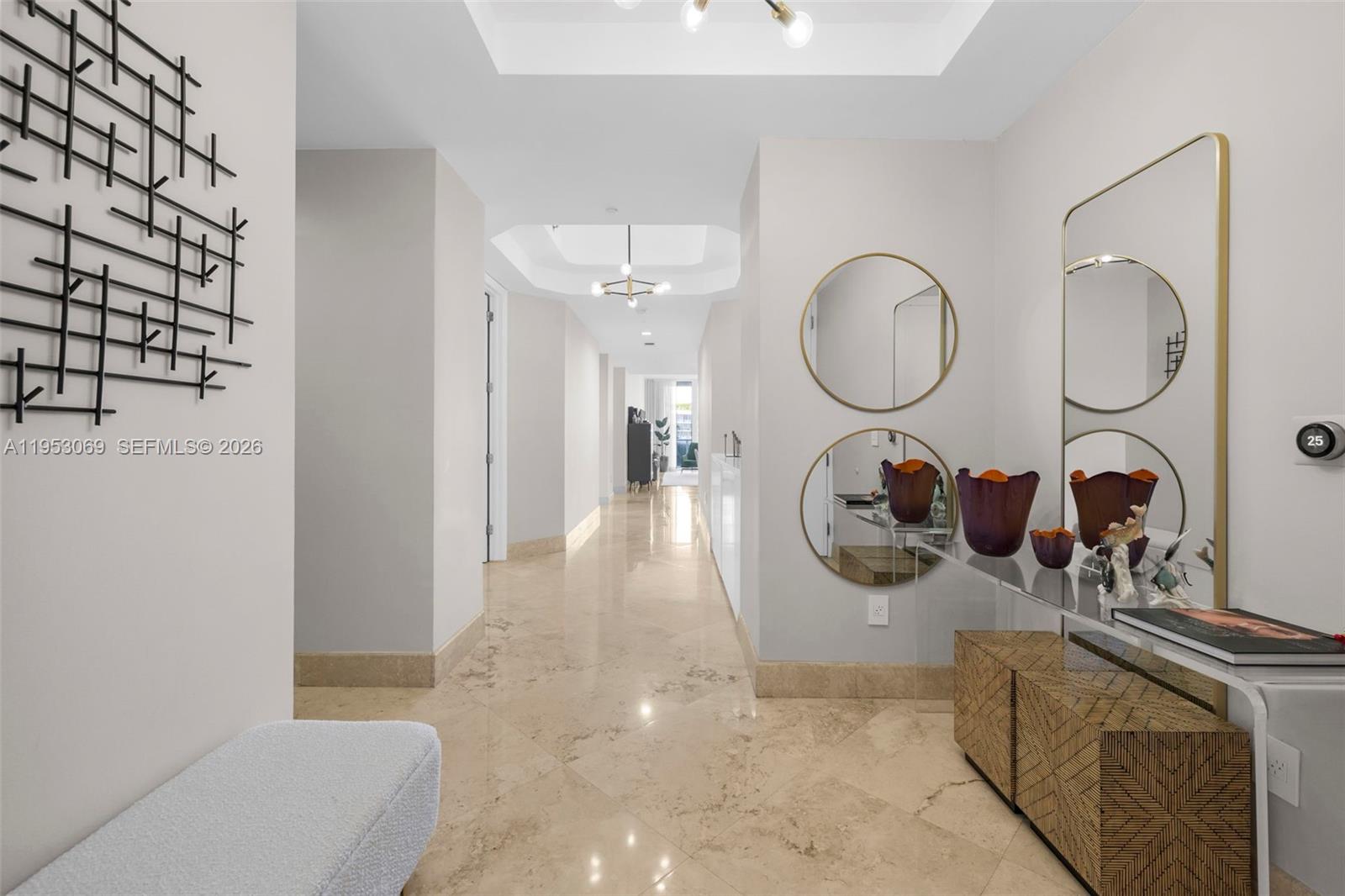 A bright hallway features marble flooring, circular wall mirrors, and a glass console table — 100 S Pointe Dr # 510, Miami Beach FL 33139, MIAMI BEACH, FL