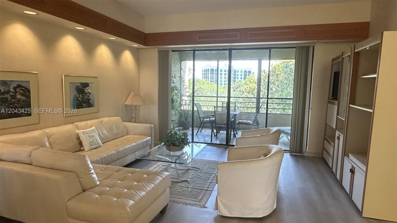 A living room features a white sectional sofa, two armchairs, and a sliding glass balcony door — 7472 La Paz Blvd # 301, Boca Raton FL 33433, BOCA RATON, FL